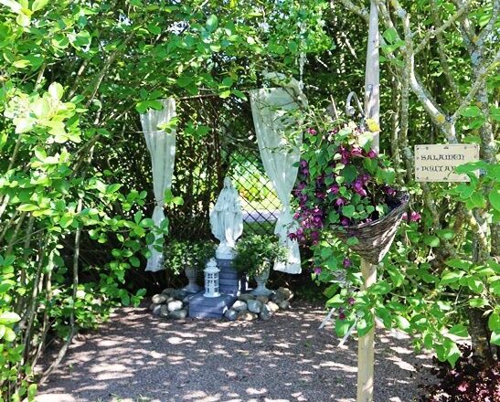 Salainen puutarha on hiljentymispaikka. Maria-patsasta reunustavat pitsiverhot.