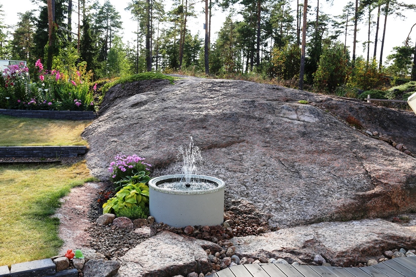 Kaivonrenkaaseen rakennettu vesiaihe antaa solisevaa ääntä muutoin kuivalle rinteelle. 