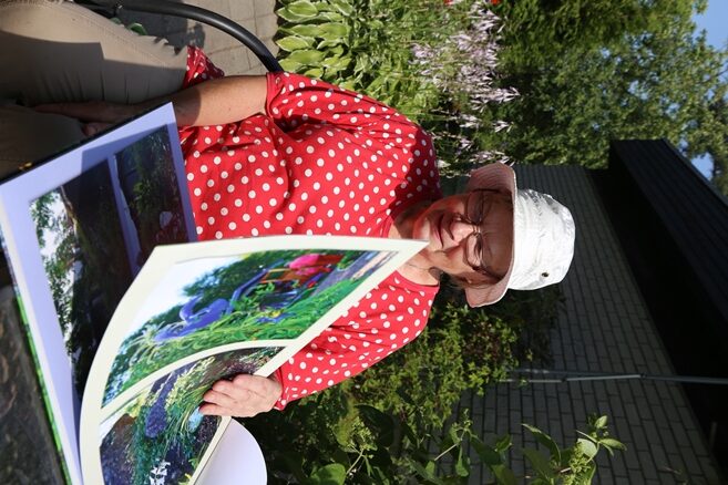 Riitta selailee kasvikirjaa, jonka hänen poikansa tytär teki mummolleen pihan kasveista.