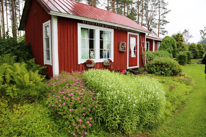 Leikkimökki on yksi pihapiirin lukuisista punaisista rakennuksista.