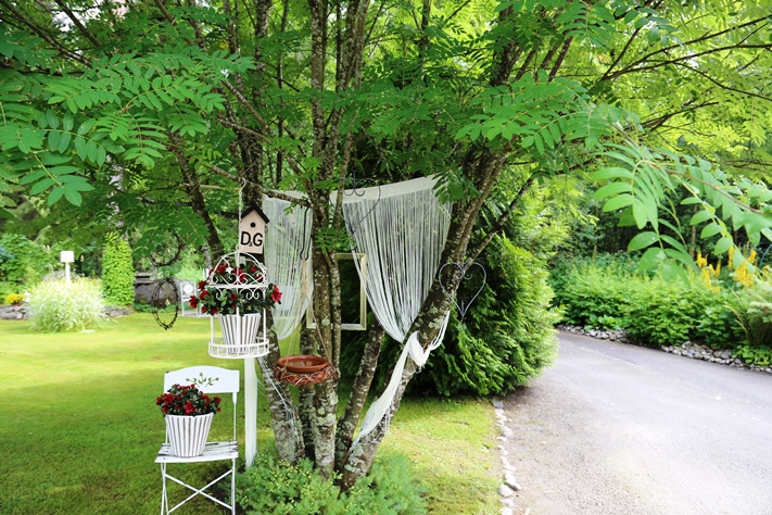 Kirsi-Marja sisustaa puutarhaa kuin kotia. Naruverhot ovat löytyneet edullisesti huonekaluliikkeestä, ja Dolce & Gabbana -muotitalossa pesii sinitiainen. 